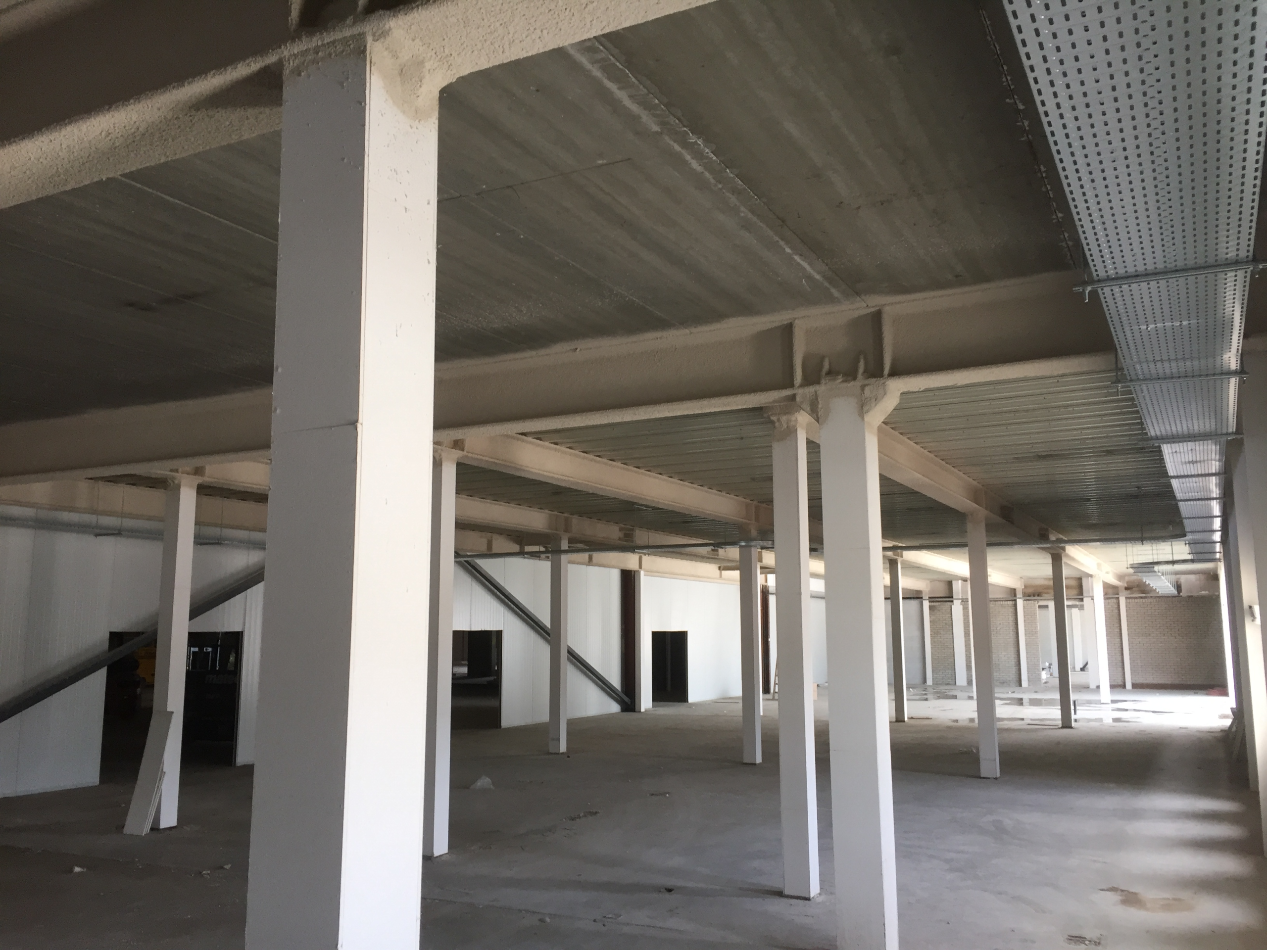 Leeg magazijn met betonnen kolommen en plafonds.