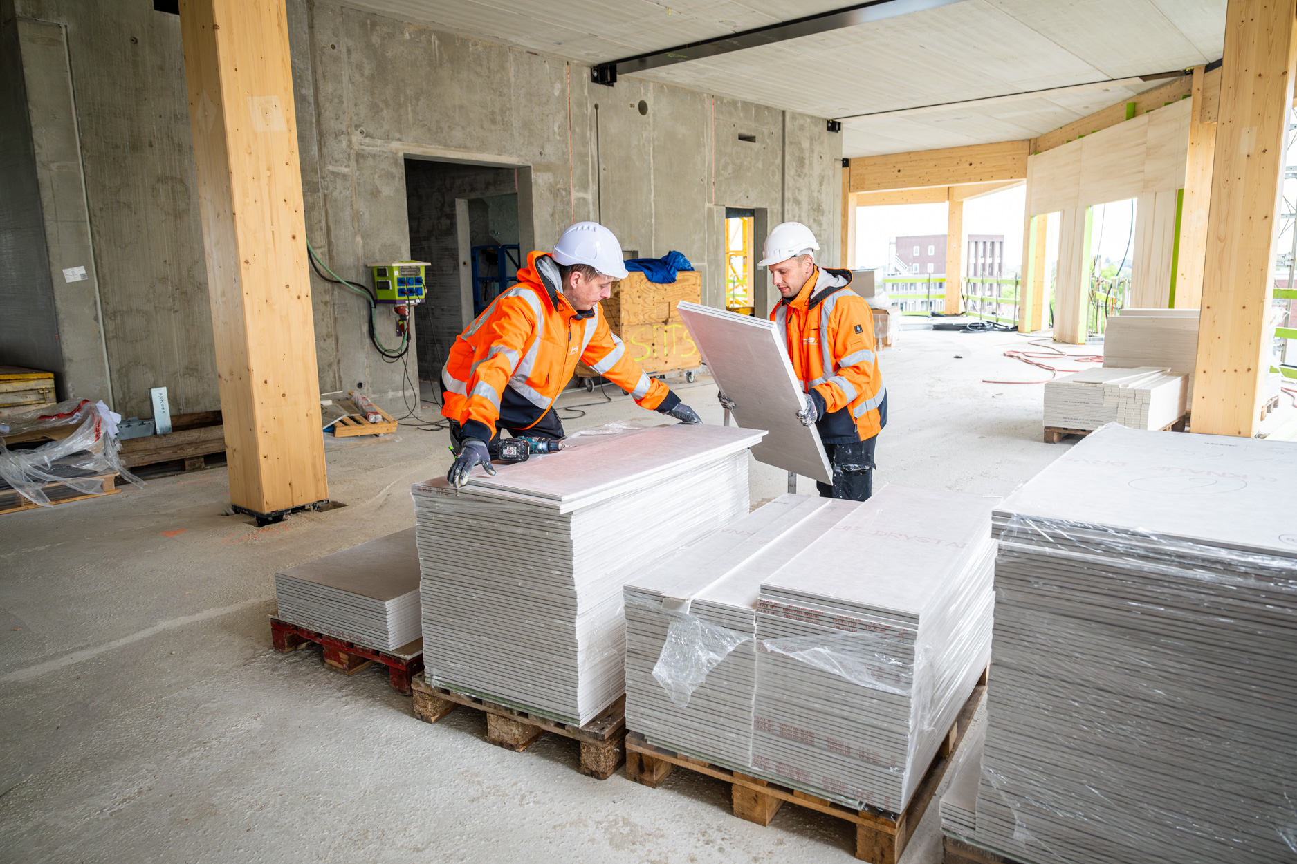 Bouwvakkers werken met panelen in een gebouw in aanbouw.