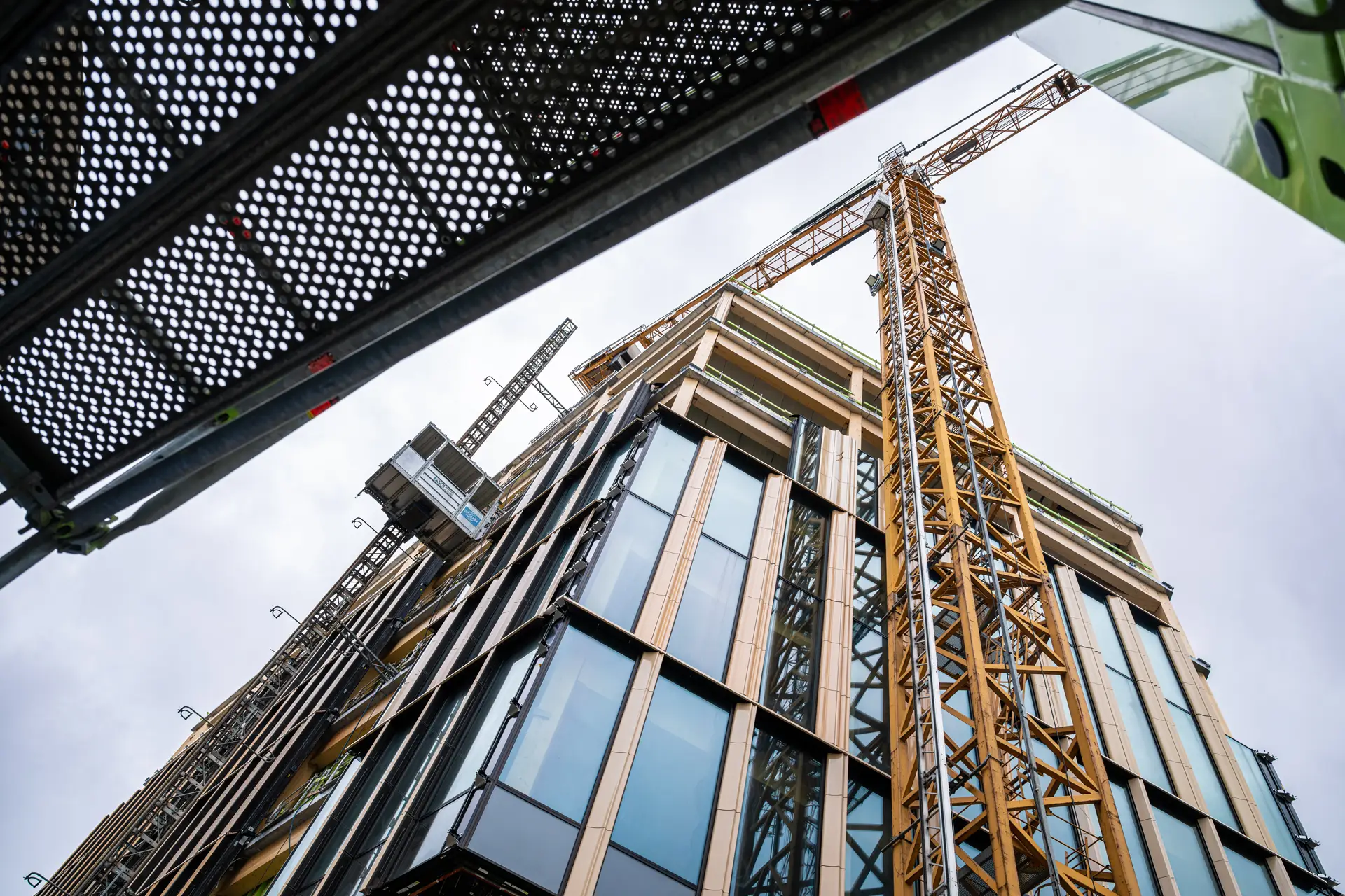 Bouwkraan bij modern gebouw in aanbouw